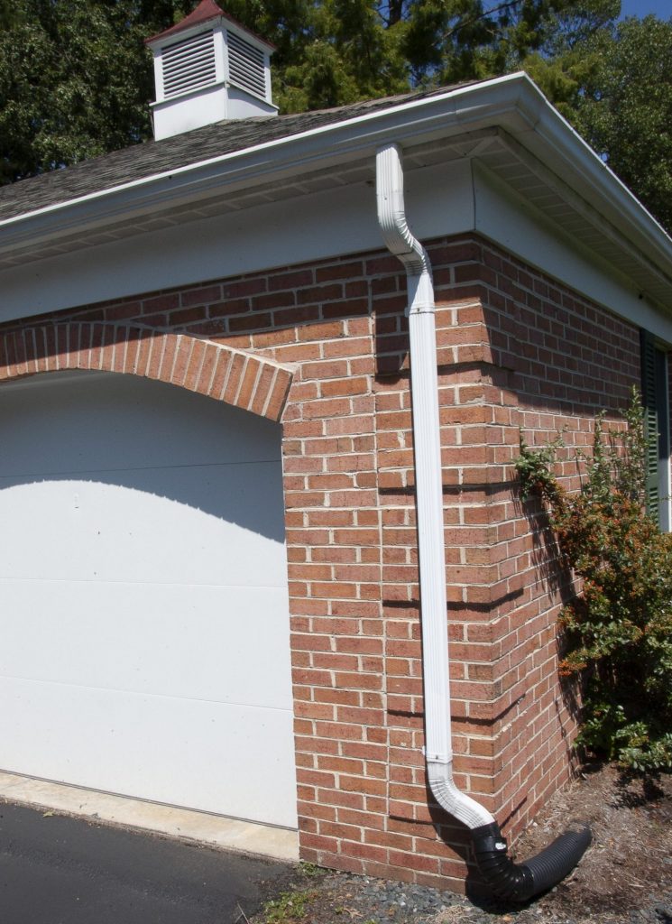 Protect the foundation of a house by inspecting gutters and downspouts to see they are clean and water flows through them.